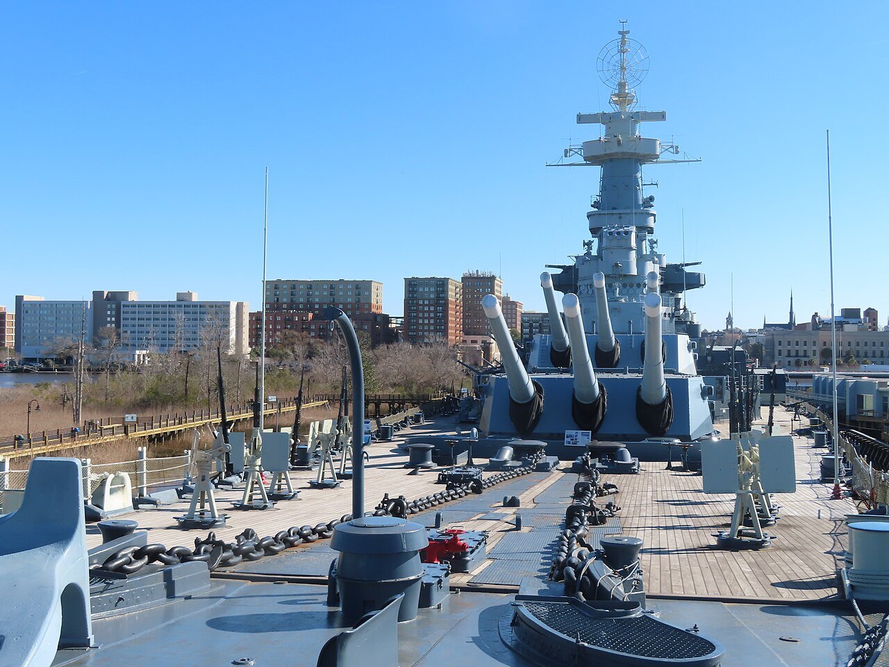 Looking forward over the deck and gun turrets of the Battleship North Carolina toward Wilmington.