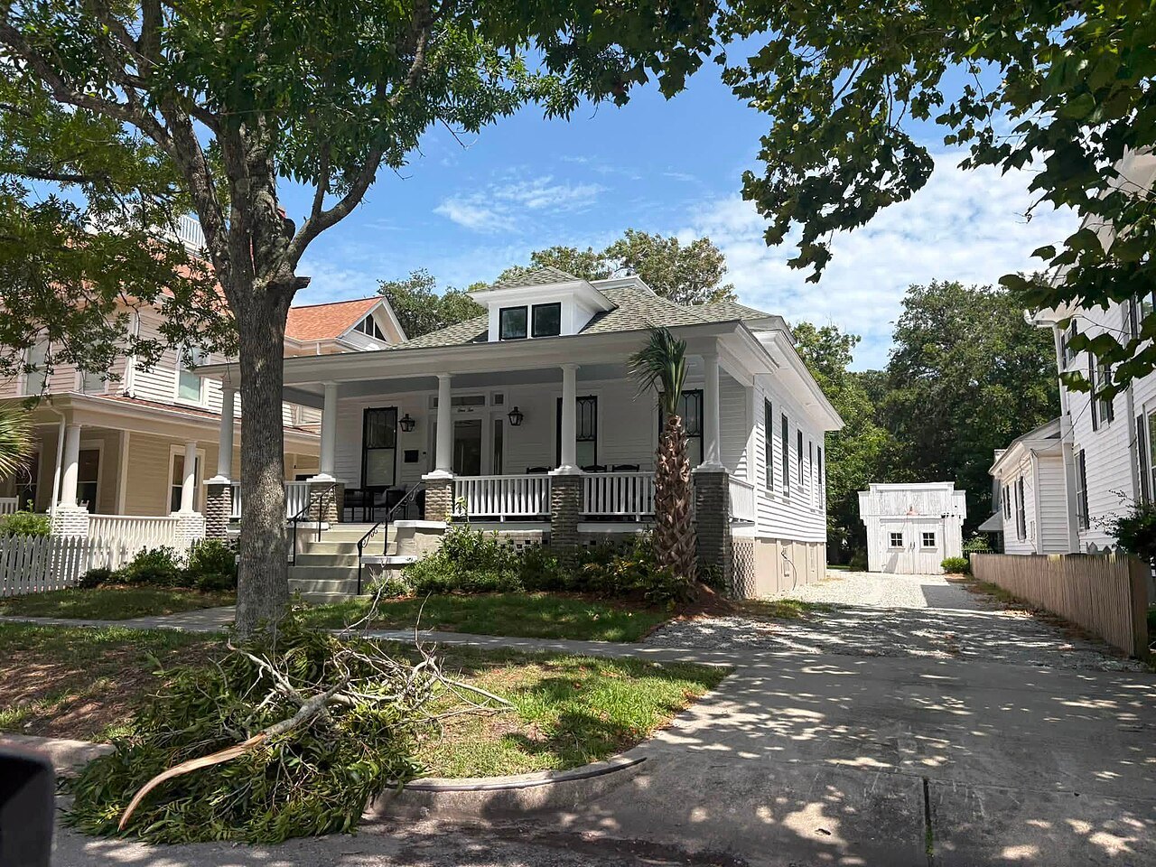 A white bungalow with a broad porch on a shady Beaufort street.
