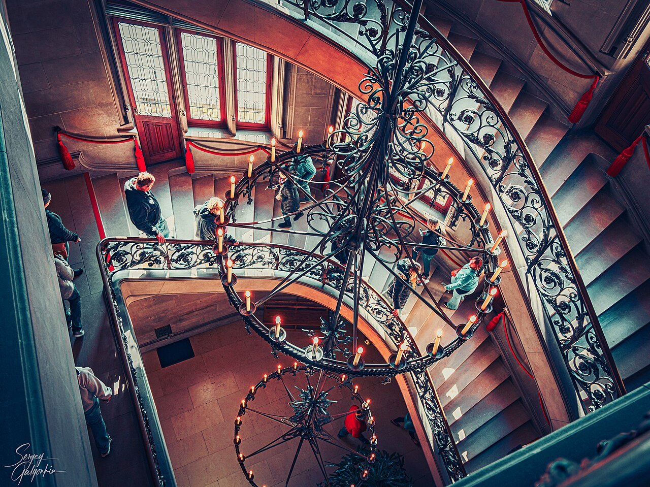 Looking down the spiral stair and its iron chandelier at Biltmore House.