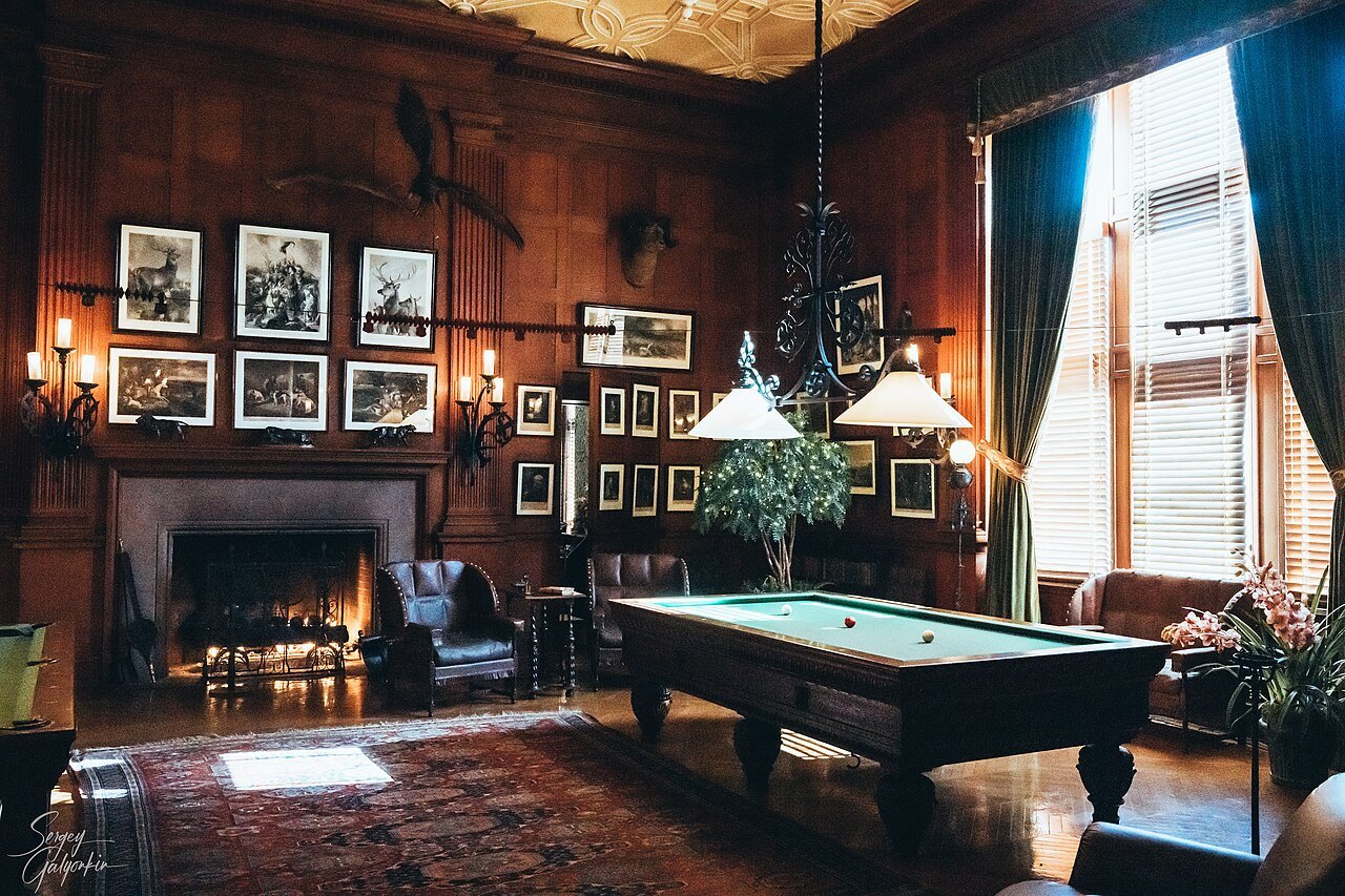 The billiard room at Biltmore House, with a fire lit in the hearth.