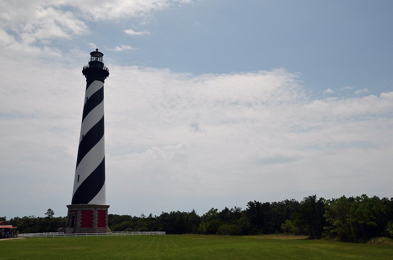 The Cape Hatteras Lighthouse above the grass of its grounds.