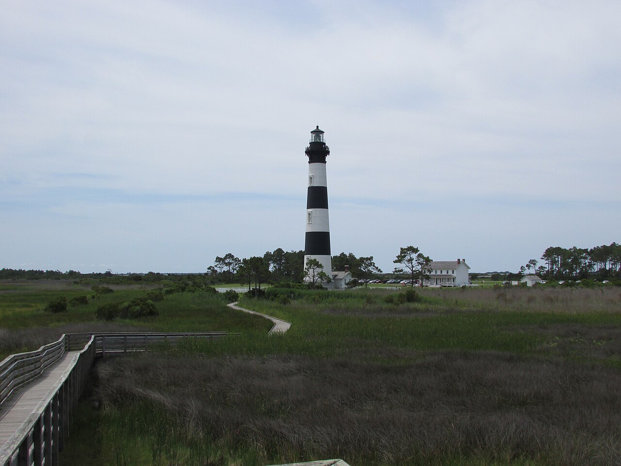 The Bodie Island Lighthouse across its marshes and boardwalk.