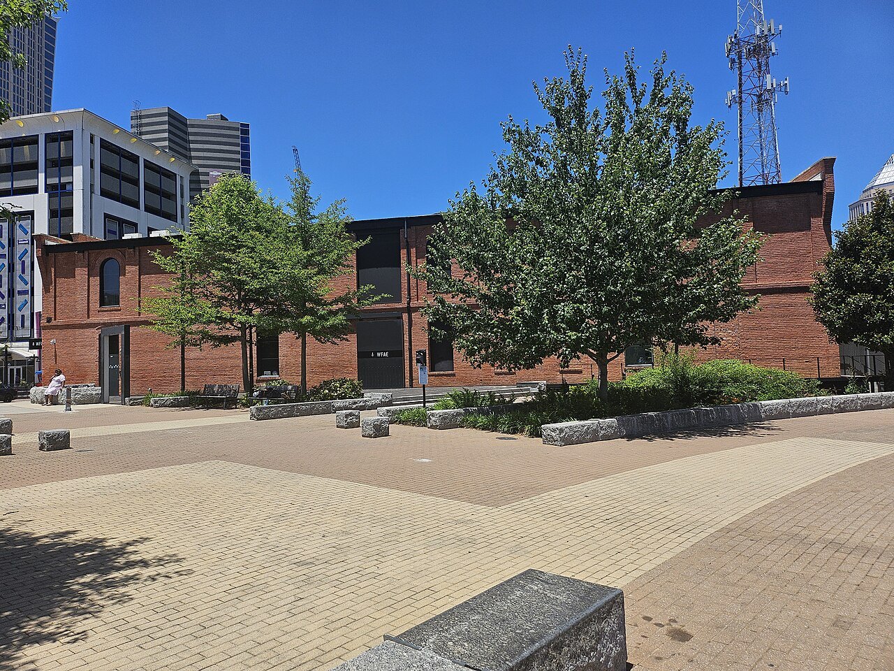 The brick Philip Carey Building beside the paving of First Ward Park.