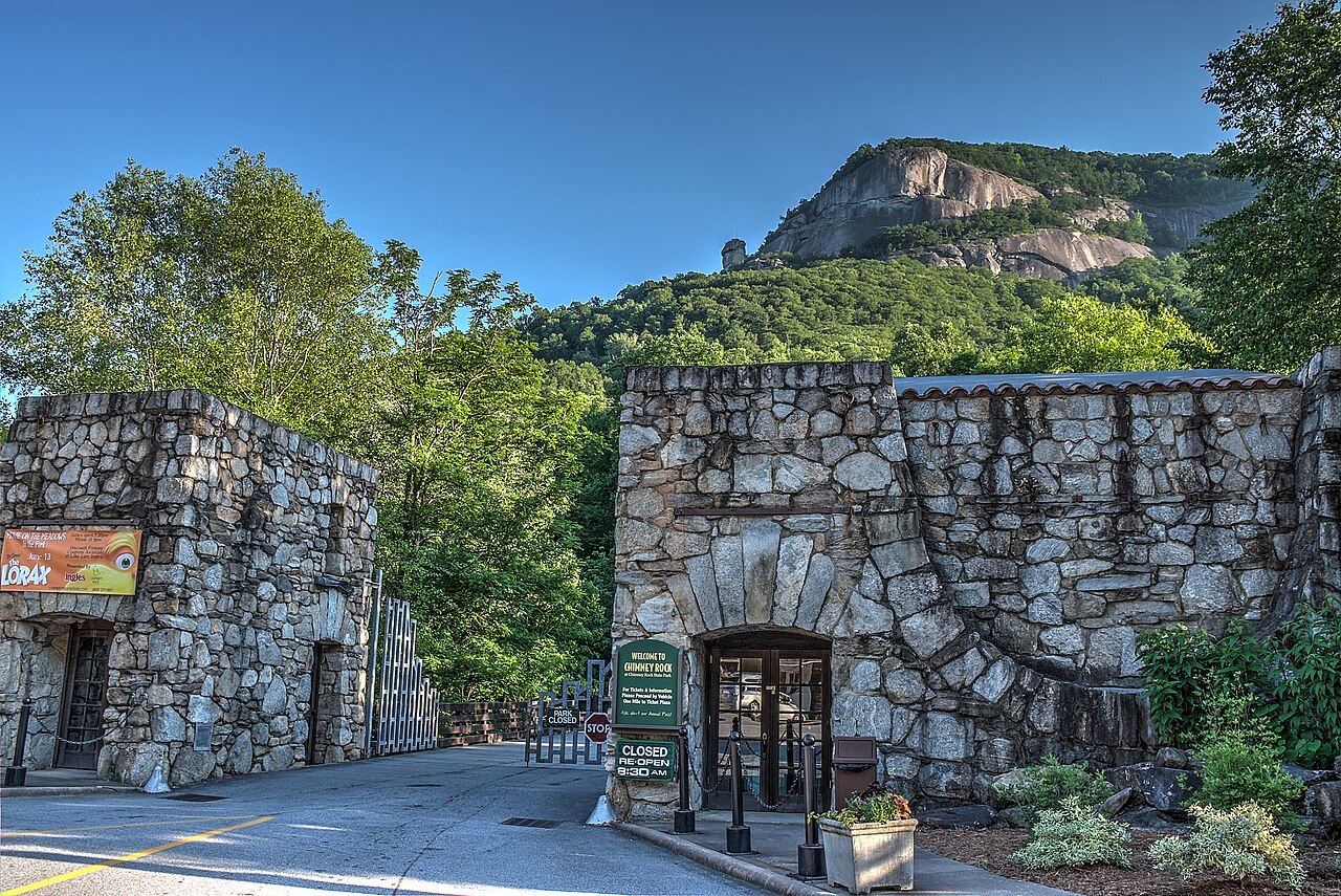 The stone entrance buildings of Chimney Rock State Park below the cliffs.