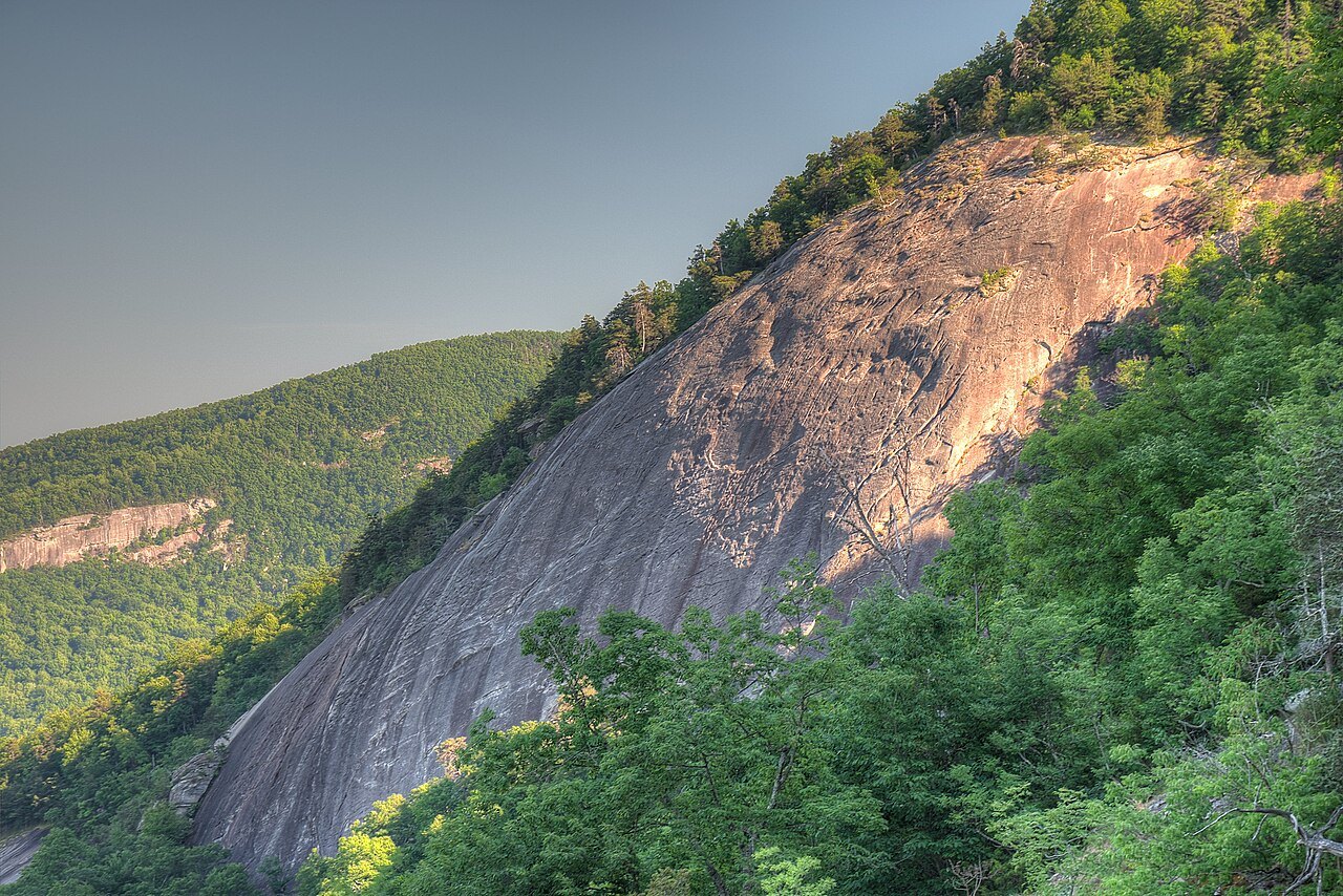 A great sloping face of bare granite rock above the forest in Hickory Nut Gorge.