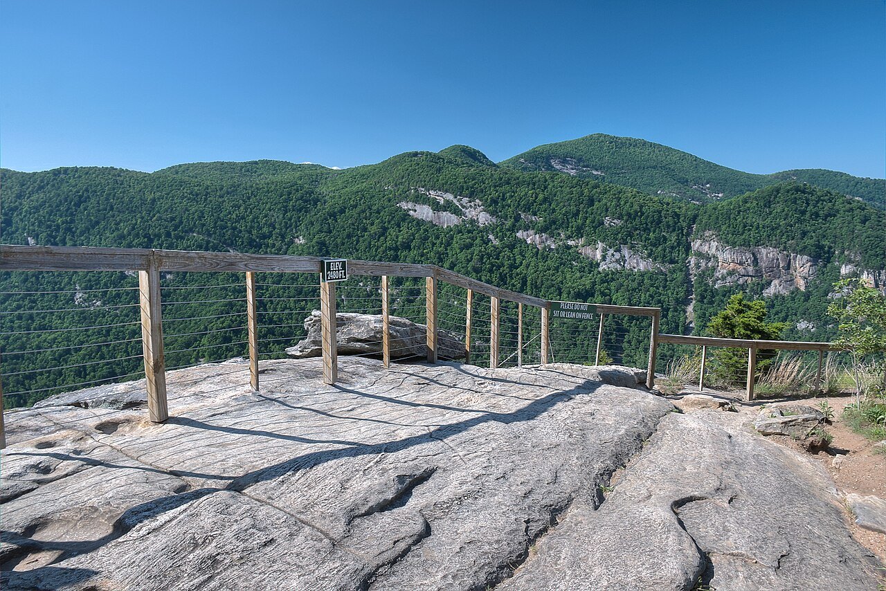 A railed lookout on bare rock above the wooded walls of Hickory Nut Gorge.