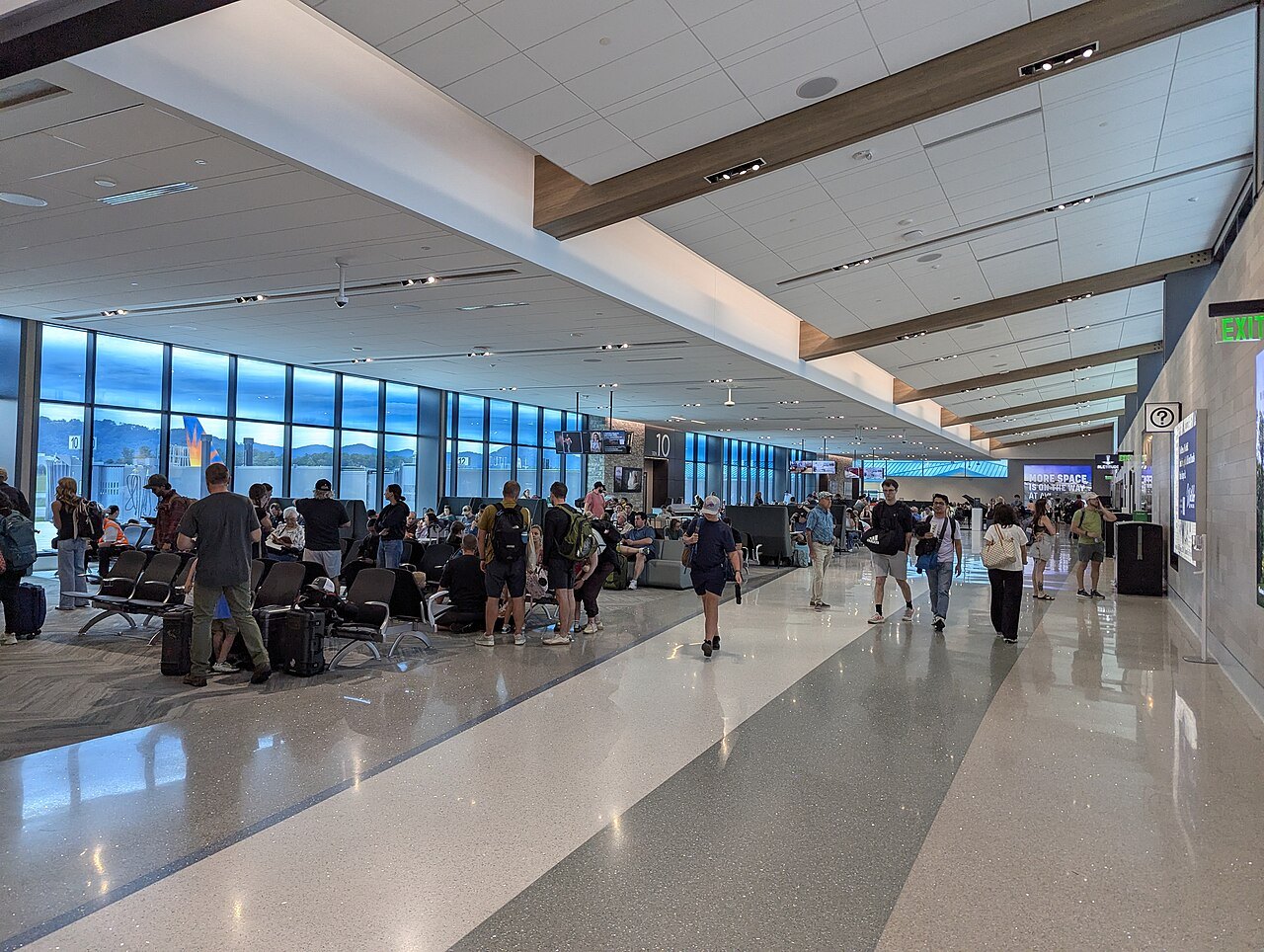 Travelers in the bright gate area at Asheville Regional Airport.