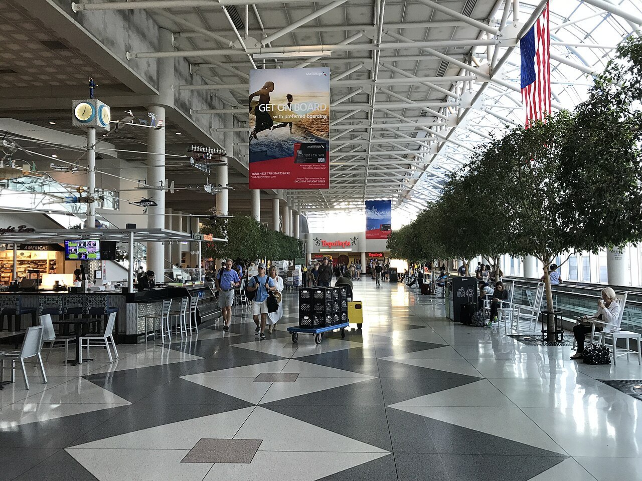 Shops and tables under the glass roof of the Charlotte Douglas atrium.