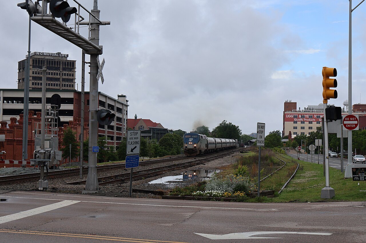 An Amtrak Carolinian train at a level crossing in downtown Durham.