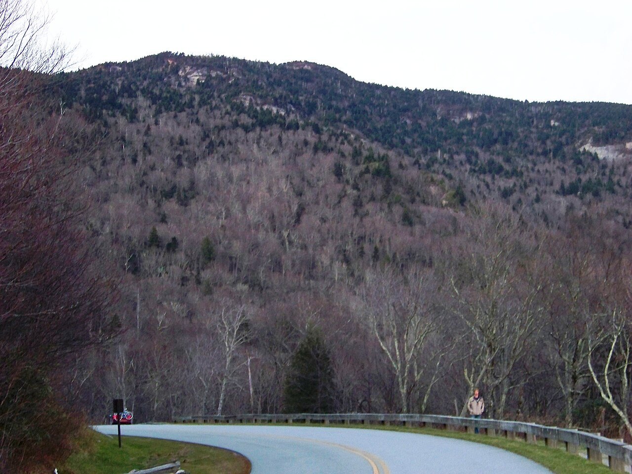 A bend of road below the wooded slopes of Grandfather Mountain.