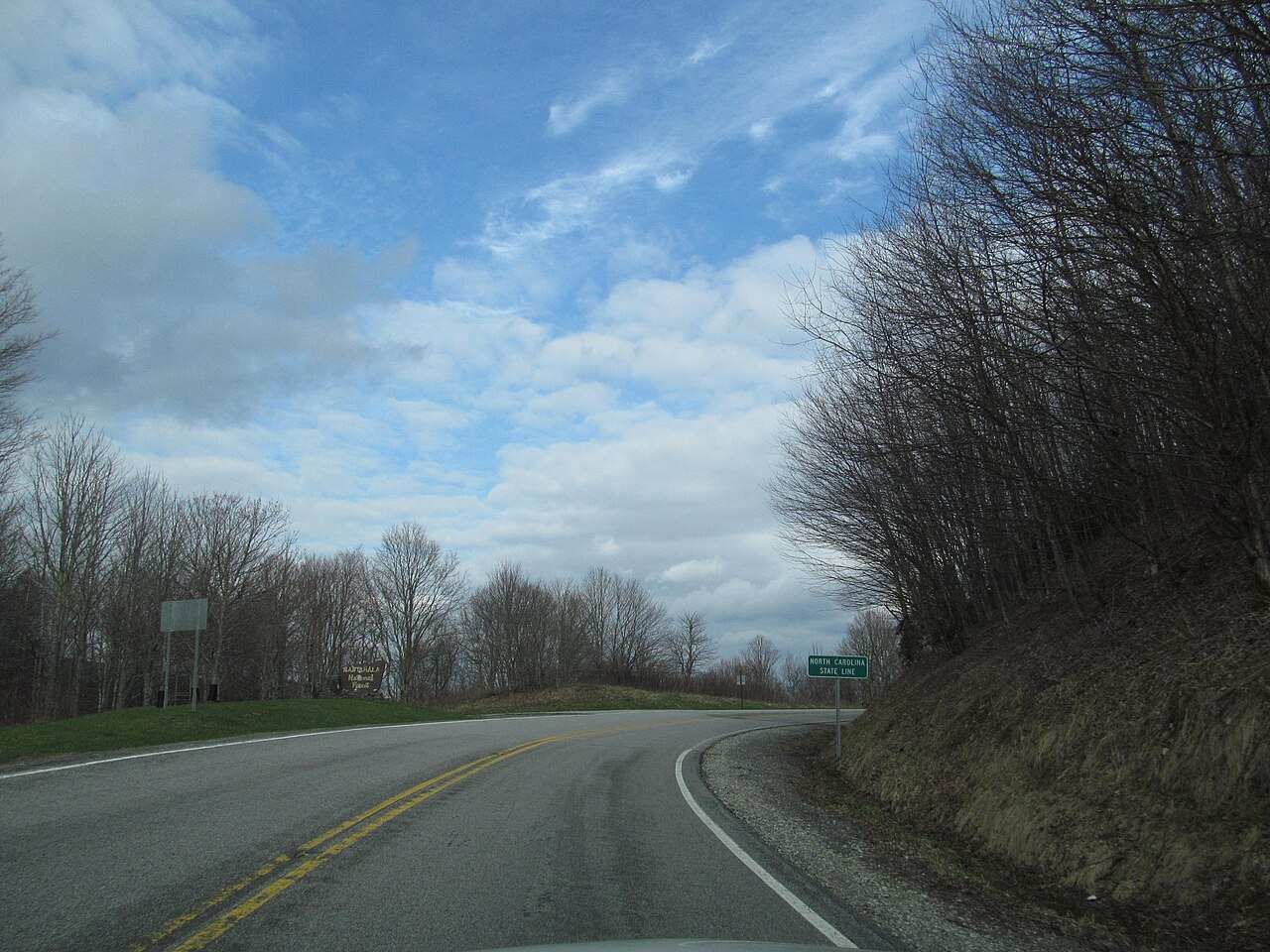 The Cherohala Skyway, NC 143, curving between bare trees.