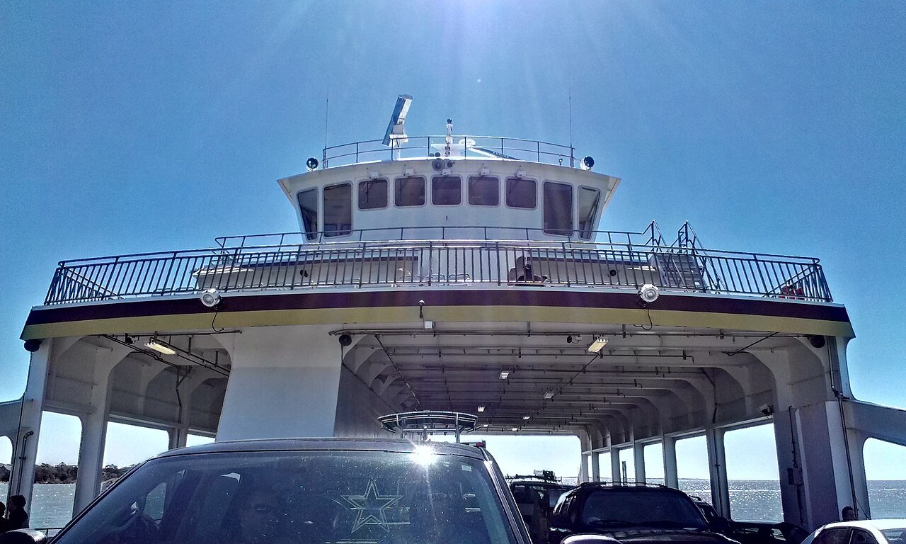 Cars parked under the bridge deck of a state ferry.