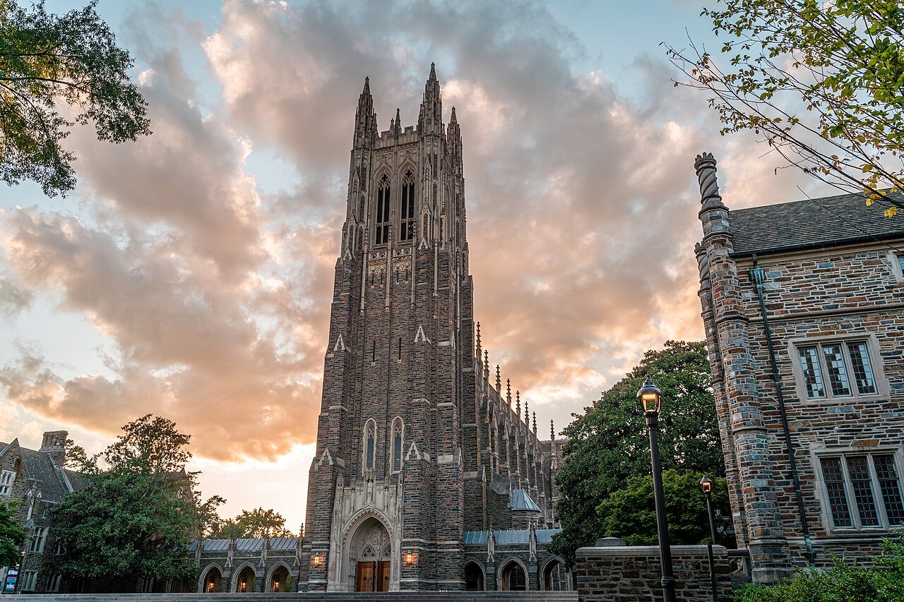 The Gothic tower of Duke Chapel against a pink evening sky.