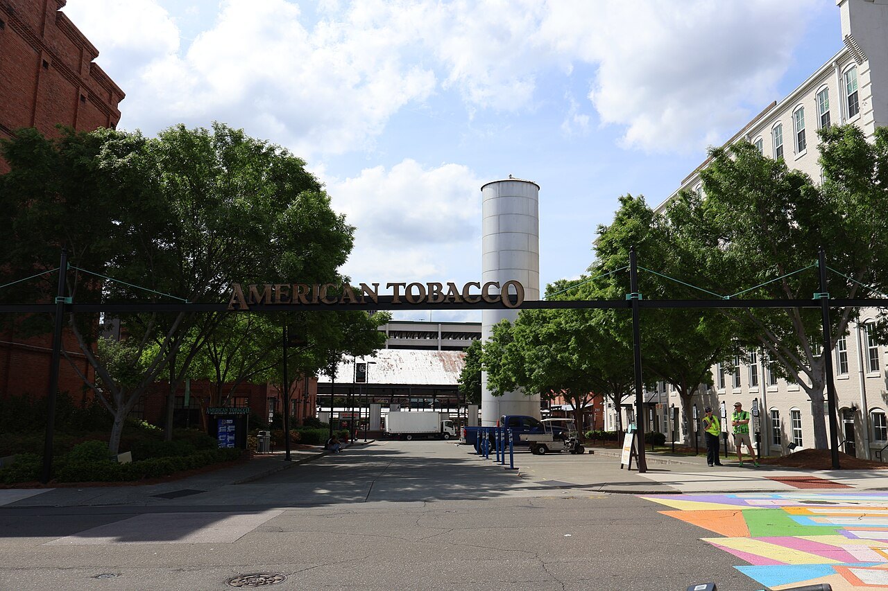 The water tower and warehouses of the American Tobacco Campus under a summer sky.
