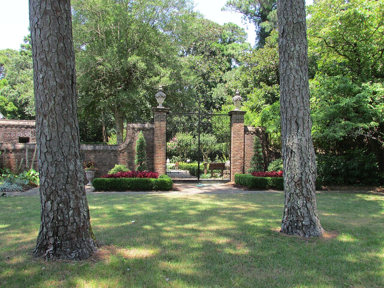 The brick front wall and gate of the Elizabethan Gardens.