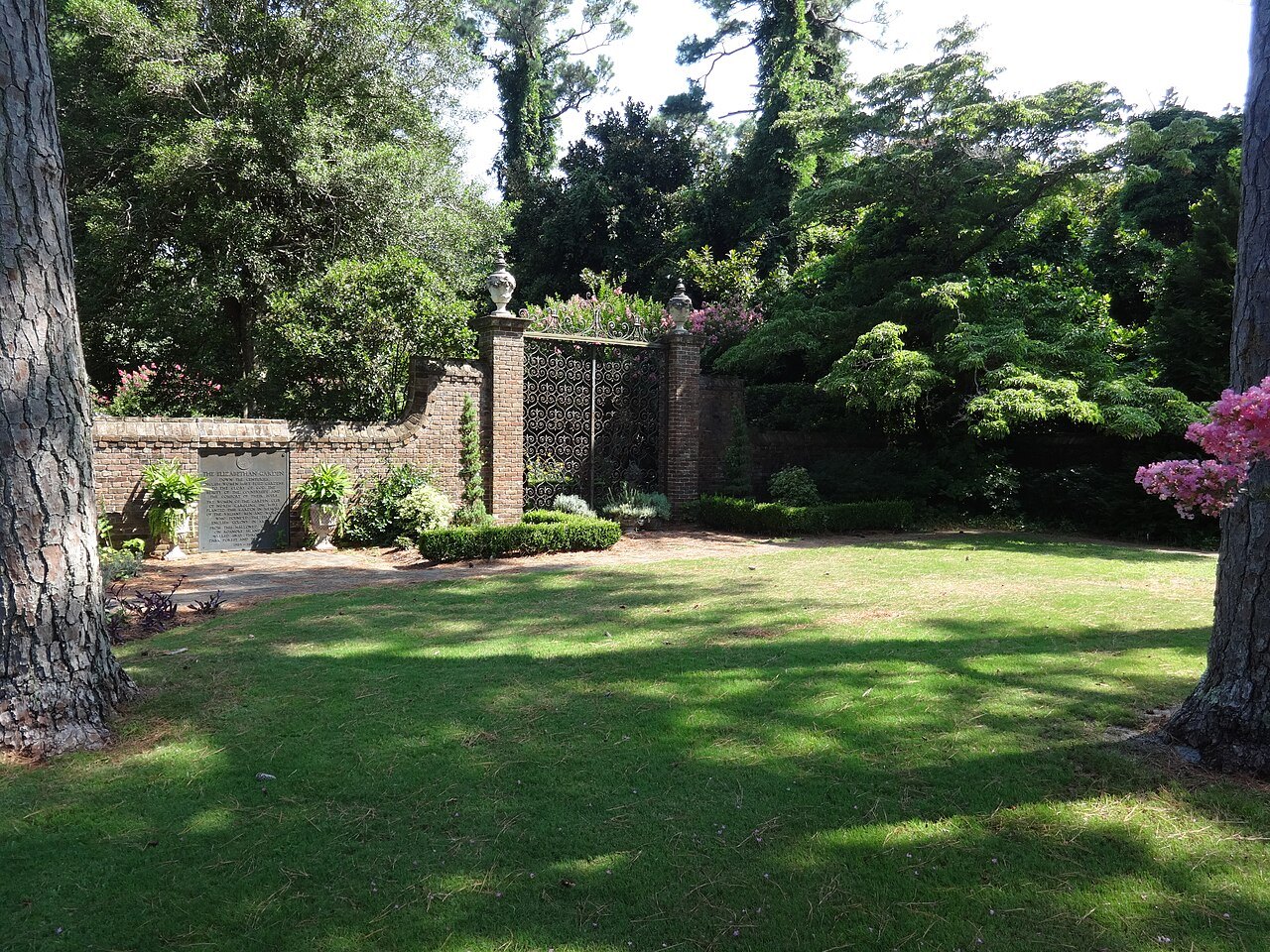A lawn and garden walls inside the Elizabethan Gardens.
