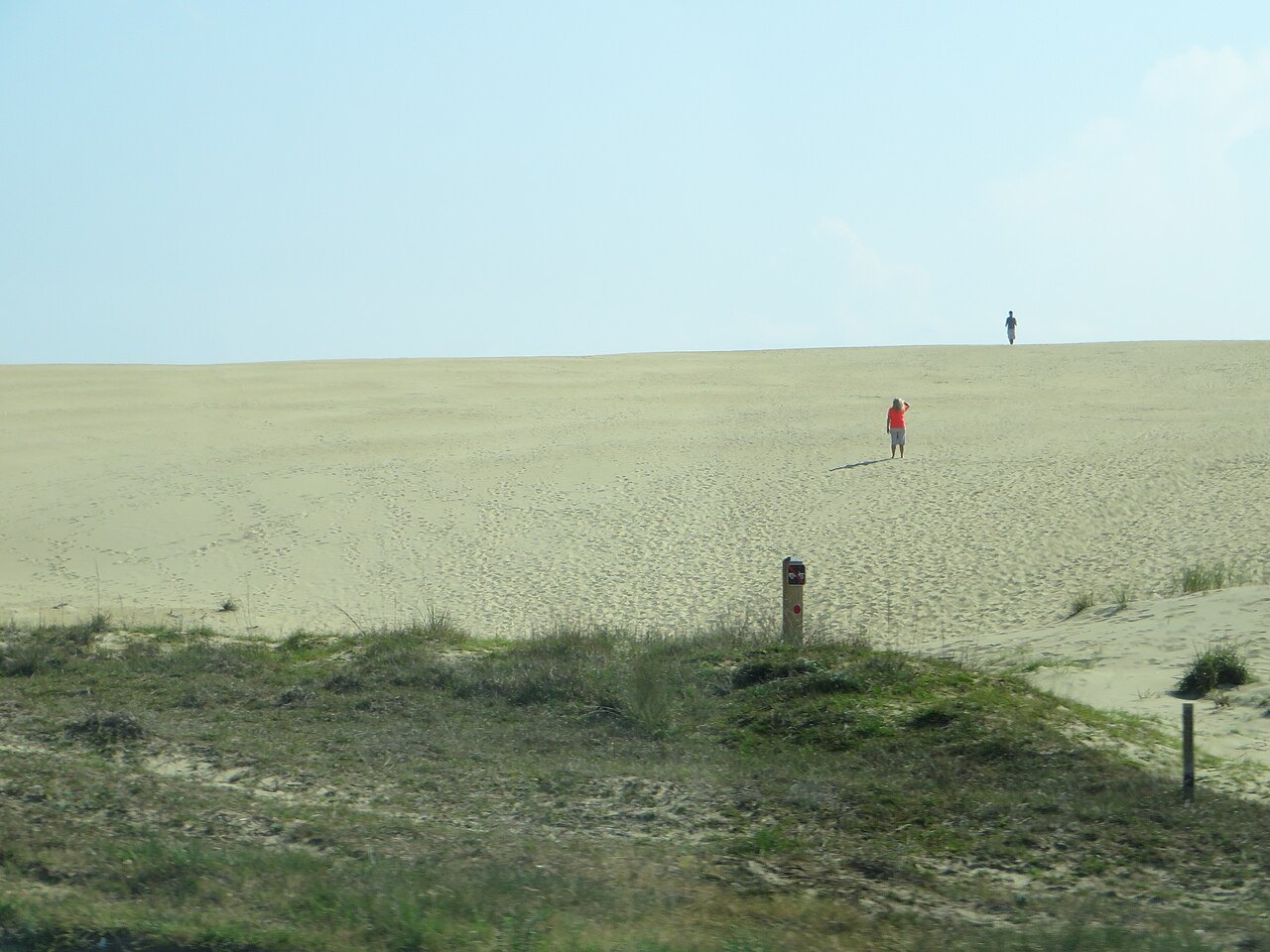 A lone walker climbing the big dune at Jockey's Ridge.