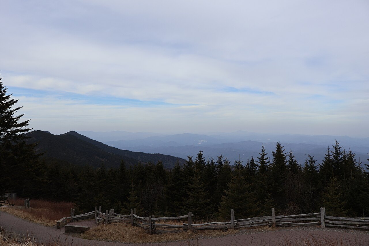 The Blue Ridge seen over the spruce and a split-rail fence in Mount Mitchell State Park.