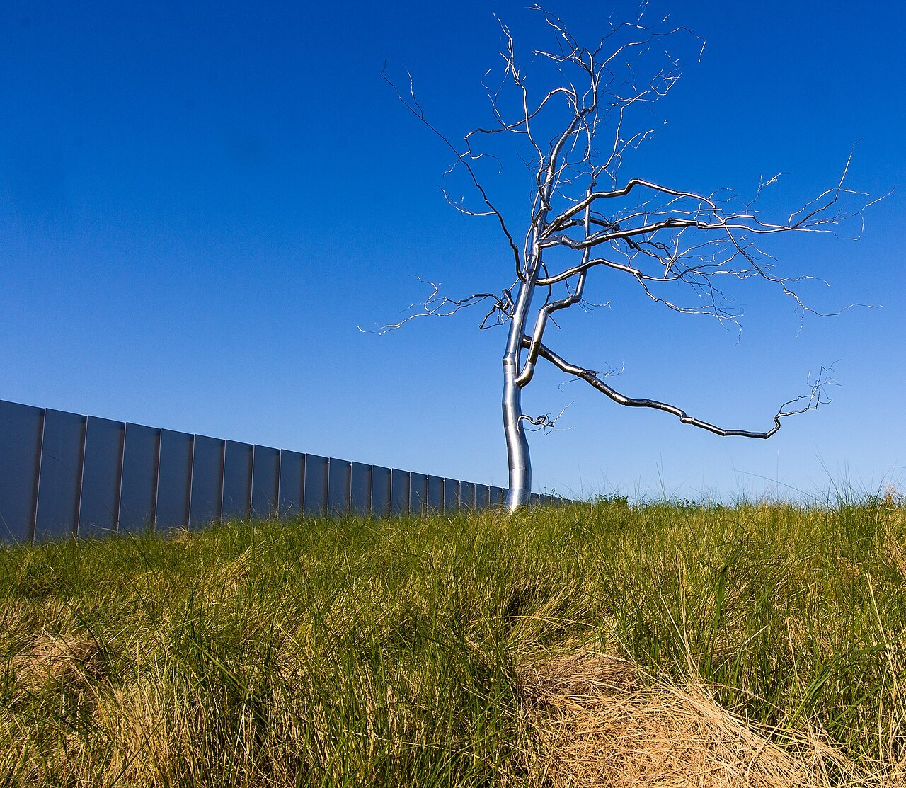 A silver steel tree sculpture beside the West Building of the Museum of Art.