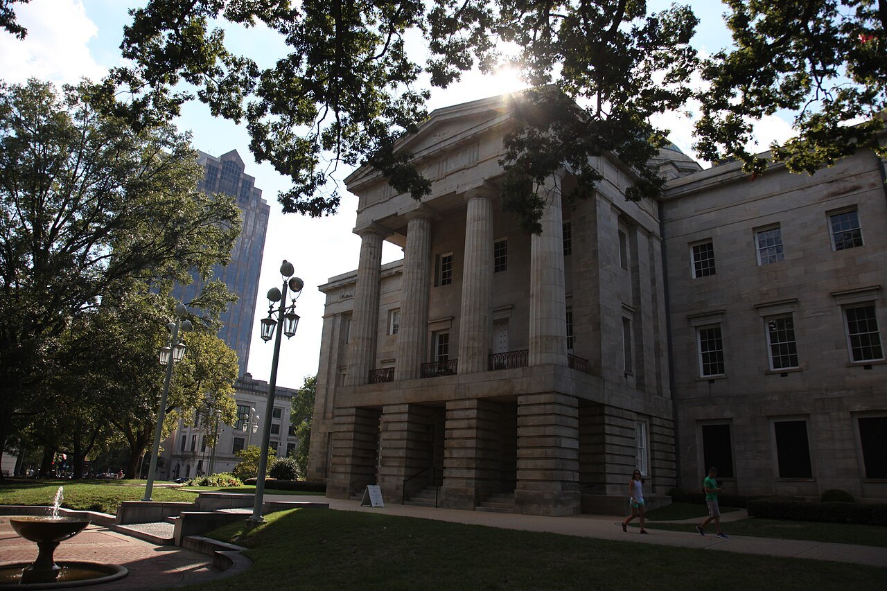 The columned east front of the State Capitol under the trees of Union Square.