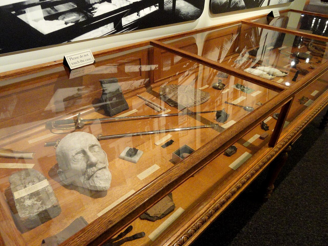 A case of objects, among them a plaster death mask, in the North Carolina Museum of History.