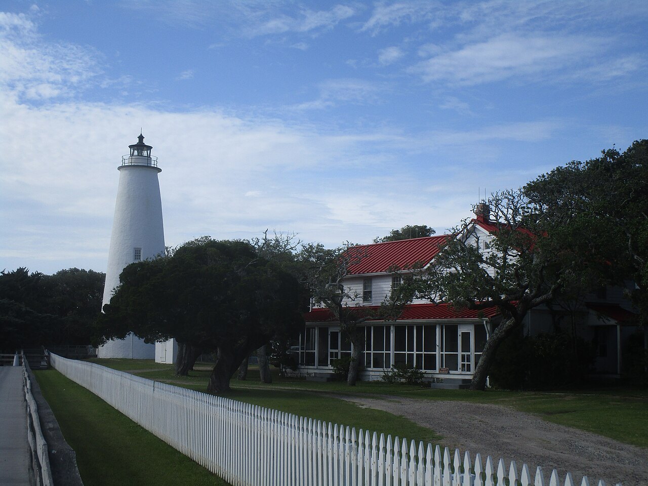 The Ocracoke Light beside the keepers' house and a picket fence.