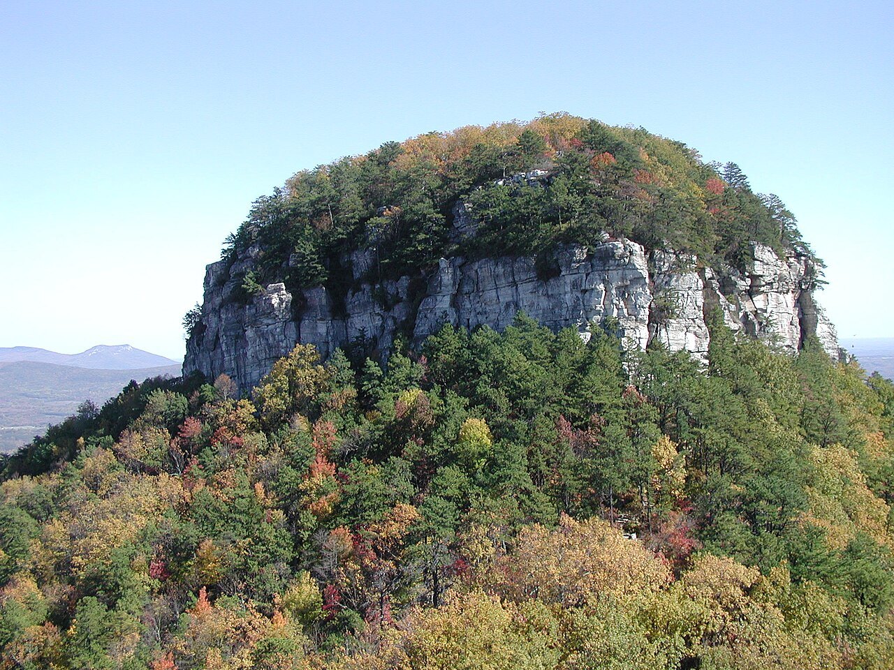 The lone quartzite knob of Pilot Mountain above the autumn forest.