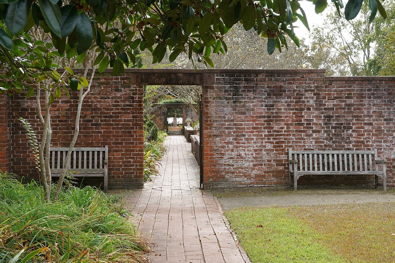 A garden walk through a brick wall at Tryon Palace.