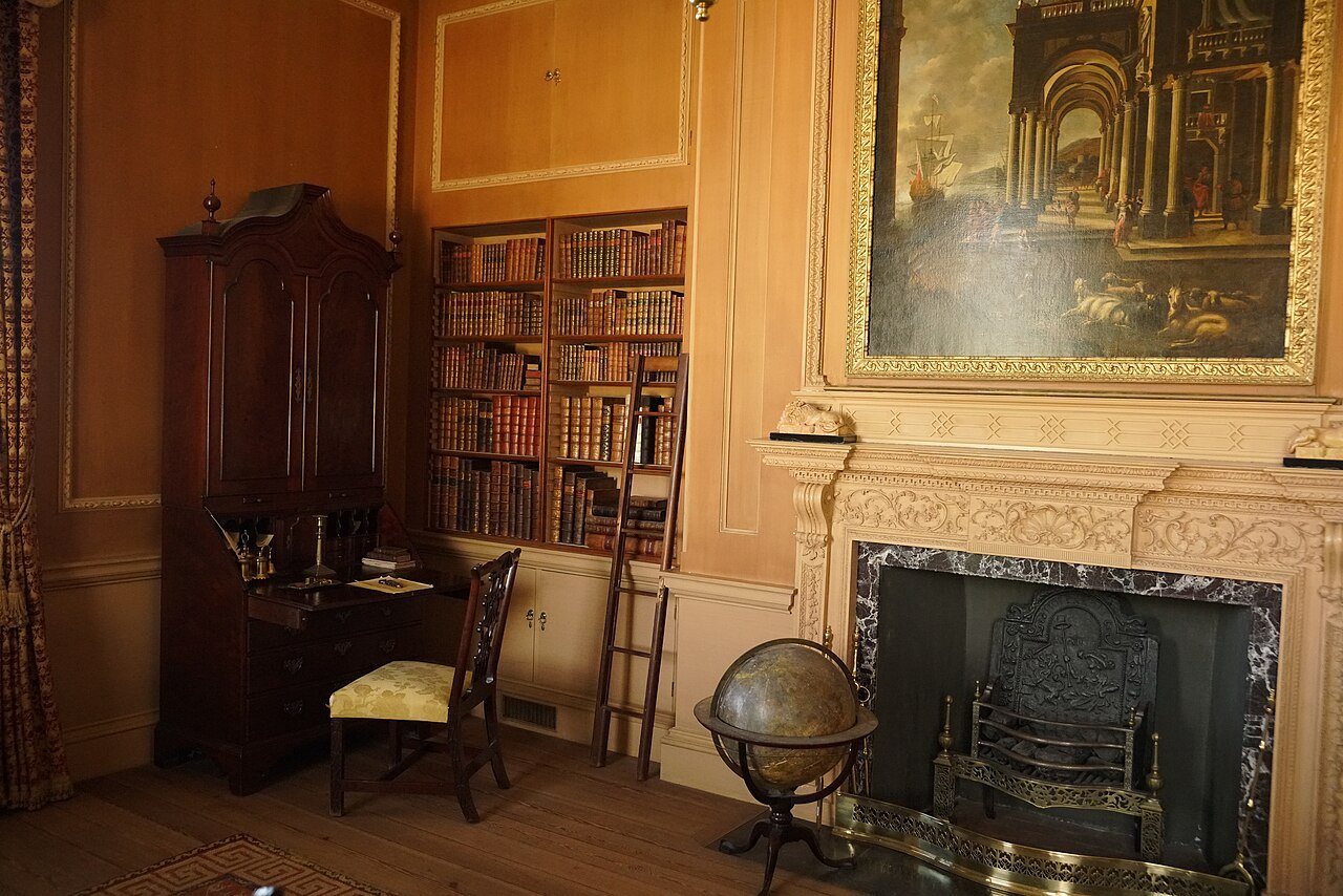 The library at Tryon Palace, with a globe and a painting over the fireplace.