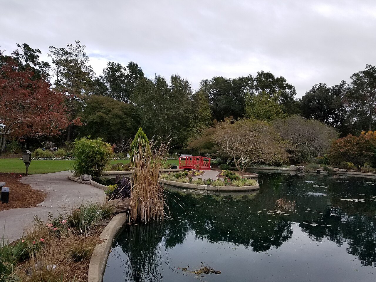 A pond and red footbridge in the New Hanover County Arboretum.