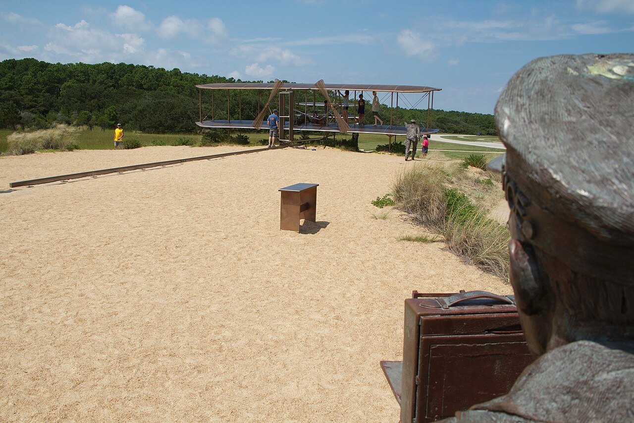 The bronze sculpture of the first flight at the Wright Brothers memorial.