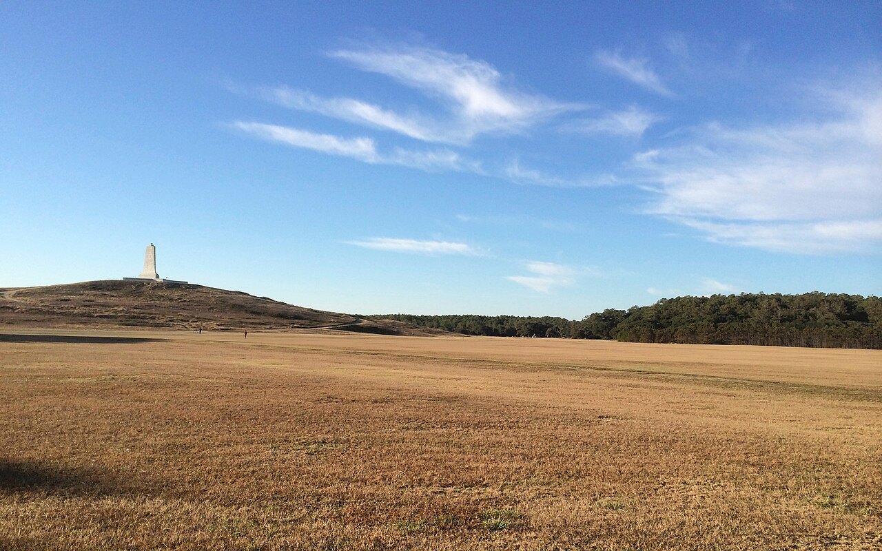 The flight field in morning light, with the memorial on the hill beyond.